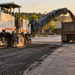 cold milling machine grinding the top layer of asphalt on a Springfield MO parking lot, showing what is asphalt milling in action